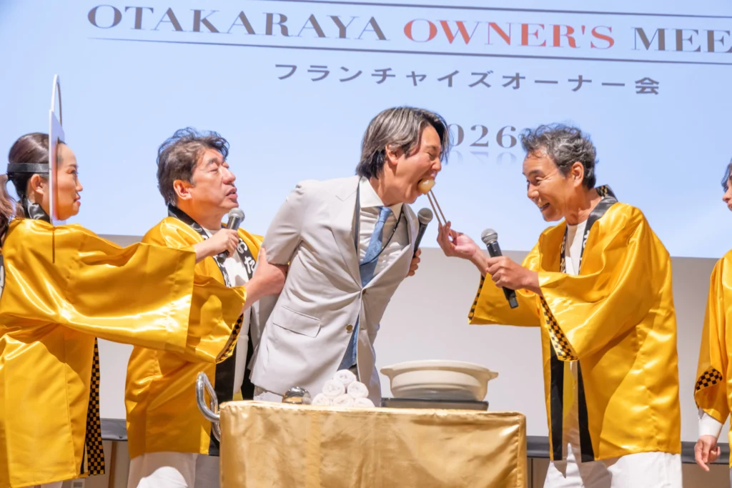 ［画像：熱々おでん芸に挑戦する塚本オーナー］